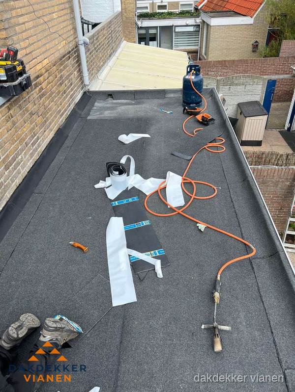 Dakdekkers bezig met bitumen dakbedekking in Vianen