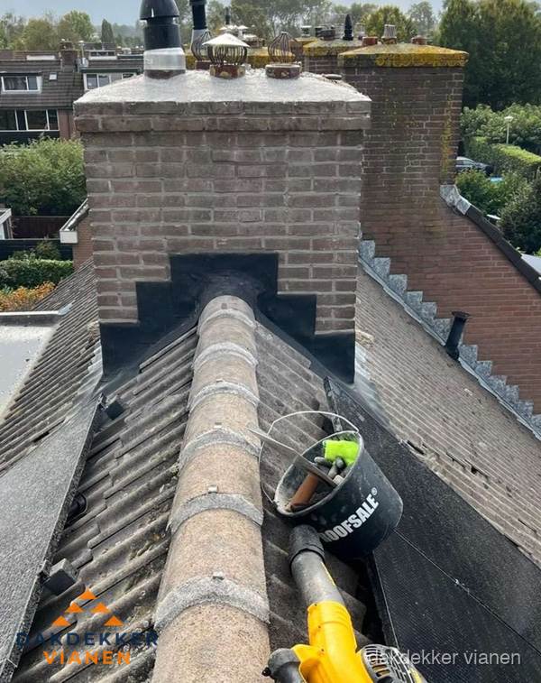 Schoorsteen met loodaansluiting en nokvorst op pannendak in Vianen