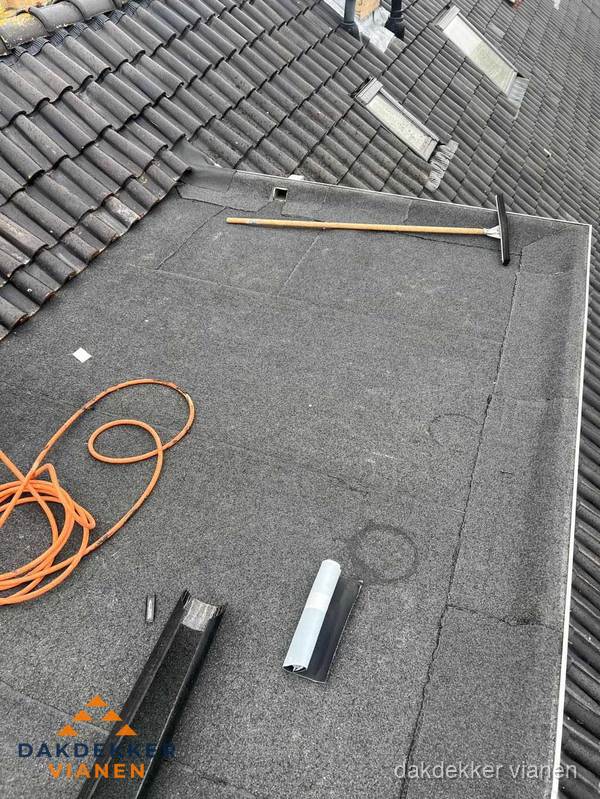 Plat dak reparatie met gereedschap en loodstroken in Vianen