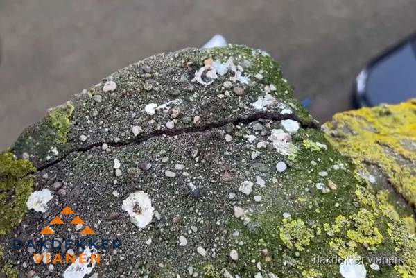 Beschadigde en verweerde nokvorst met scheuren en mos in Vianen
