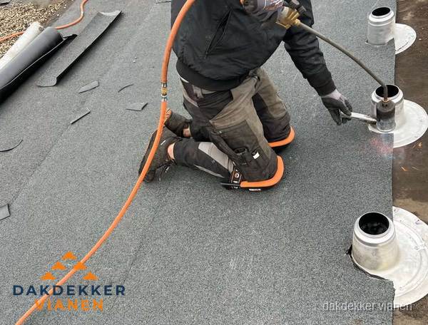 Dakdekker repareert bitumen dakleer bij dakdoorvoer in Vianen